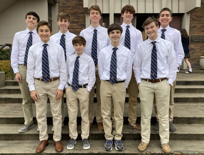 Nine boys in uniform stand on stone steps at St. Paul’s School, a renowned school for boys on the Northshore of LA.