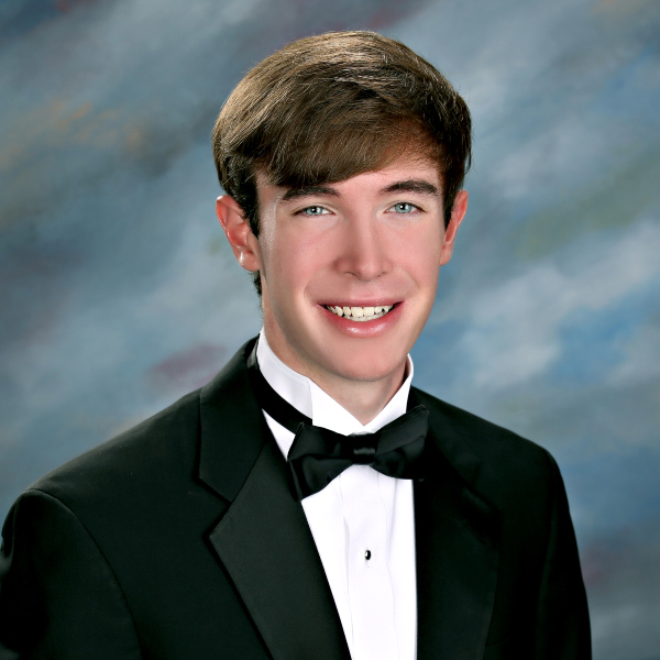Young man in a black tuxedo with a bow tie poses, representing St. Paul's School, a leading school for boys on the Northshore.