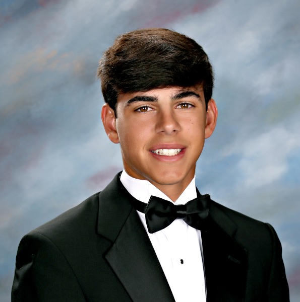 A young man wearing a black tuxedo and bow tie poses for a formal St. Paul's School portrait, the premier school for boys on the Northshore, LA.