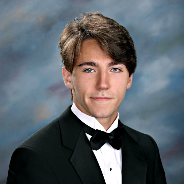 A young man in a black tuxedo poses for a formal portrait, representing St. Paul's School, a leading private school on the Northshore.