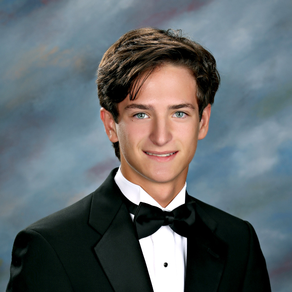 Young man in a black tuxedo, smiling at the camera—an alum of St. Paul's School, a top school for boys on the Northshore, LA.