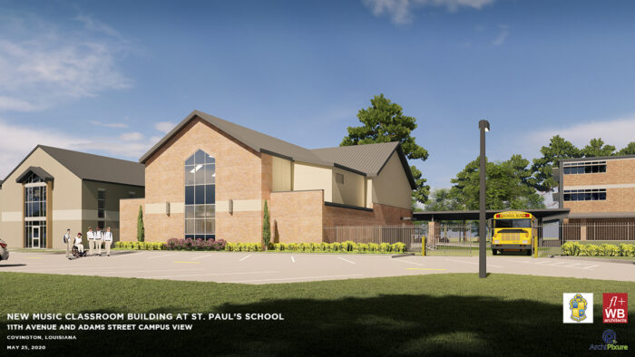 A new brick music classroom at St. Paul's School, with large windows, a group of people, cars, and a yellow school bus outside.