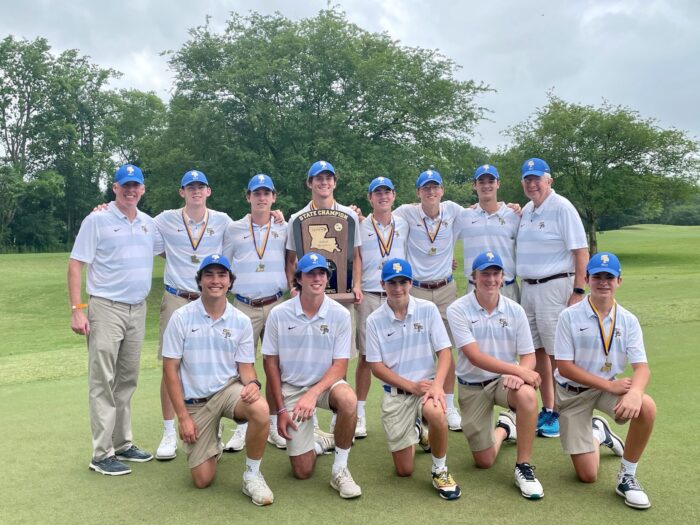 The St. Paul's School boys' golf team poses on grass with medals and a state champion plaque, wearing white shirts, shorts, and blue hats.