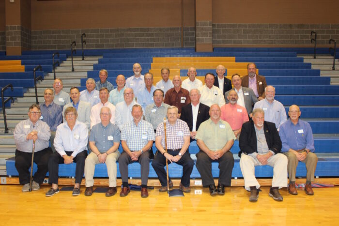 A group of older men pose for a group photo on the bleachers at St. Paul’s School gymnasium on the Northshore.