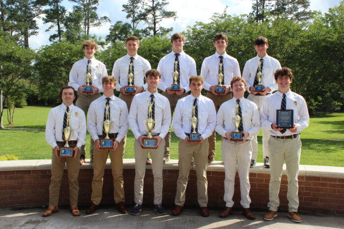 Eleven young men from St. Paul's School pose outdoors, each holding a trophy or plaque—proud achievers at this school for boys northshore LA.