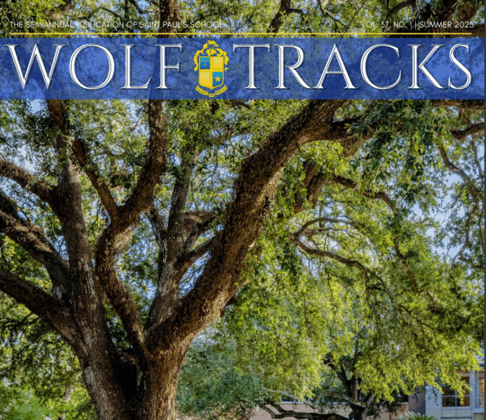 Large oak tree with sprawling branches shades a brick walkway as Wolf Tracks welcome students to the school building on a sunny Summer 2025 day.
