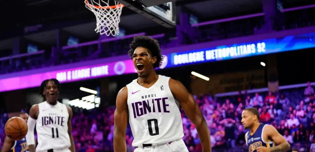 A G League Ignite player celebrates near the basket as another young basketball player looks on during the indoor game.