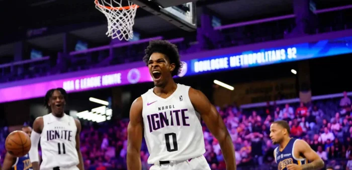 A G League Ignite player celebrates near the basket as another young basketball player looks on during the indoor game.