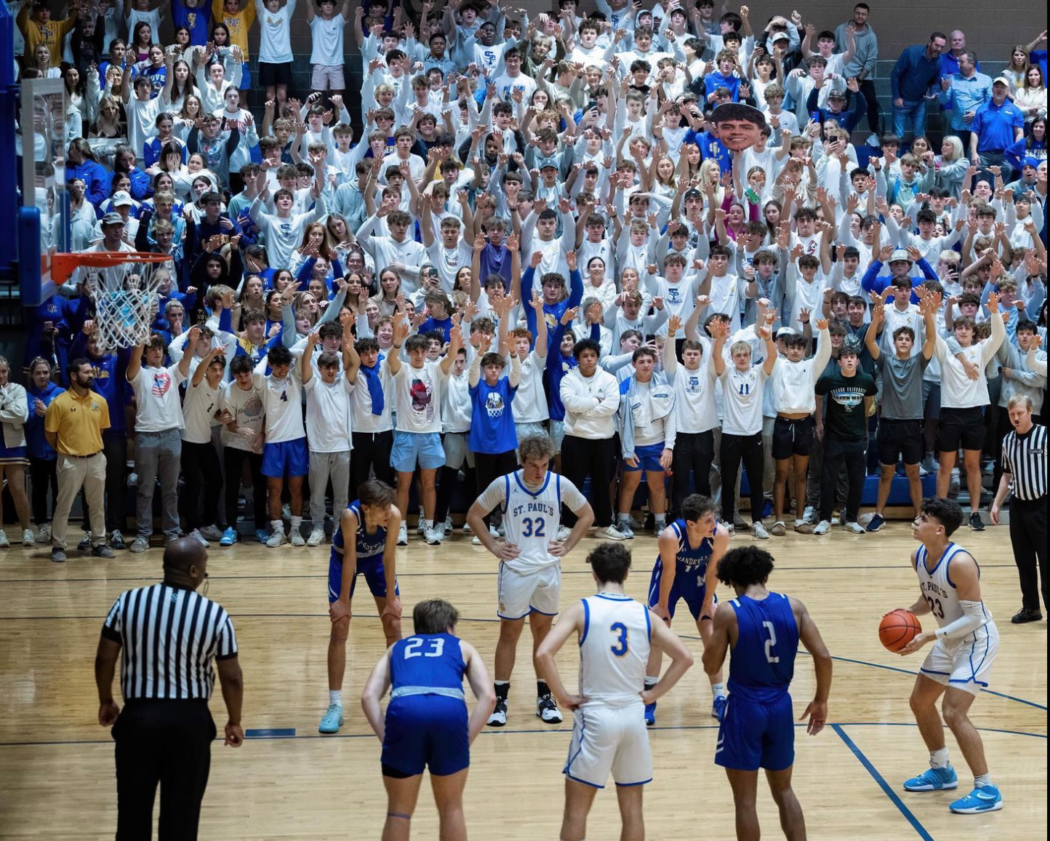 A Seicshnaydre player prepares for a free throw as Basketball Wolves and Mandeville High Skippers watch in a crowded gymnasium.