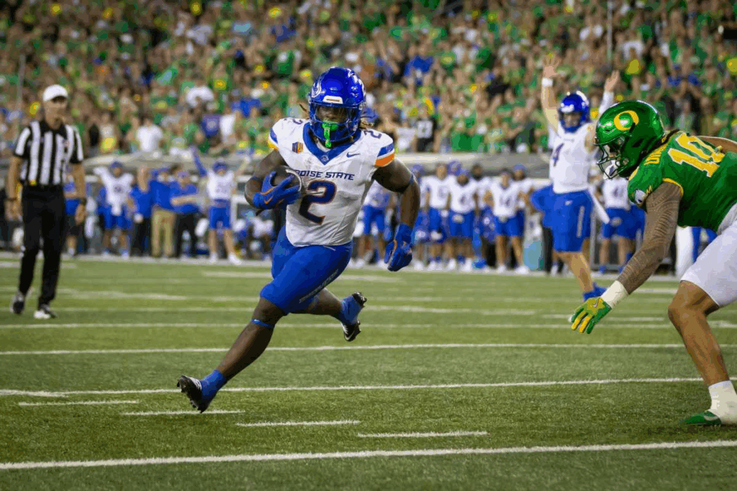 Boise State's Ashton Jeanty runs with the ball as an Oregon defender closes in, thrilling spectators and adding buzz to the Heisman race.