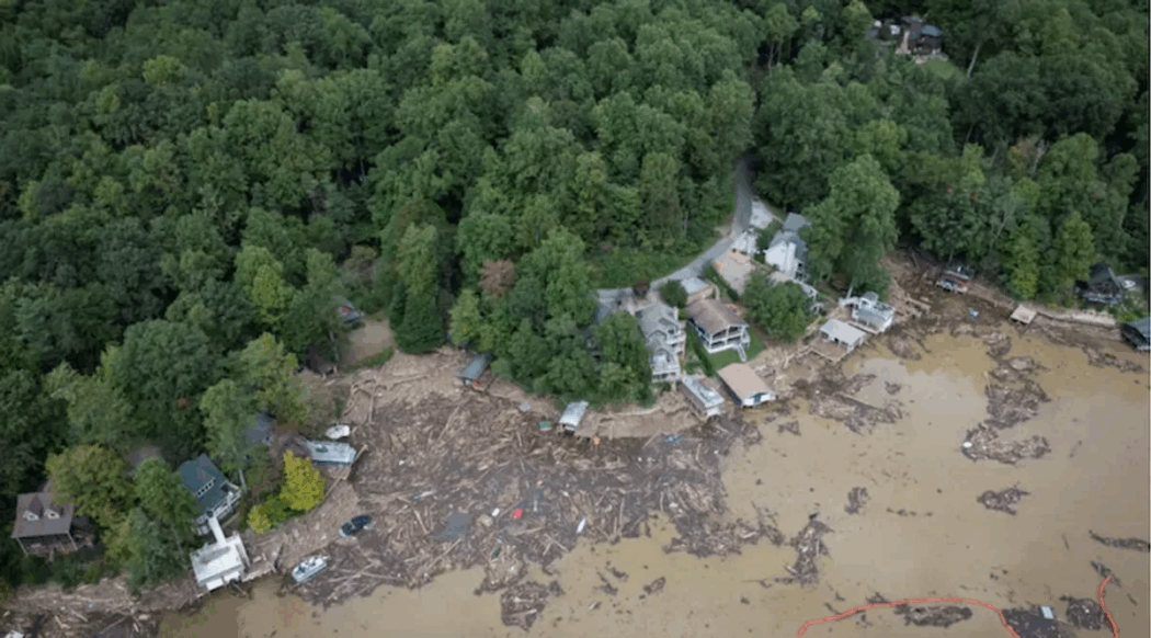 Aerial view of houses by a forest with flooding resembles the uncertainty in 2024 presidential election prediction.