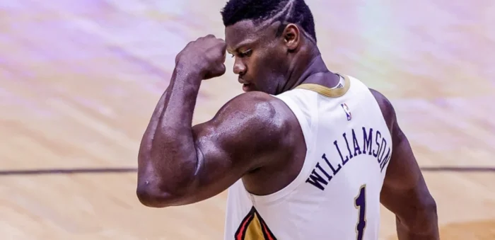 Zion Williamson flexes his right arm on the court, ready to lead the Pelicans in the 2024-25 season.